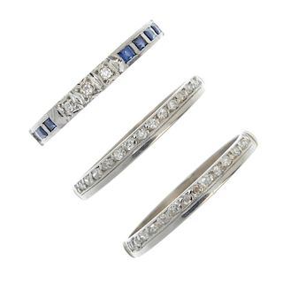 A selection of three diamond and gem-set full and half-circle eternity rings. The first designed as