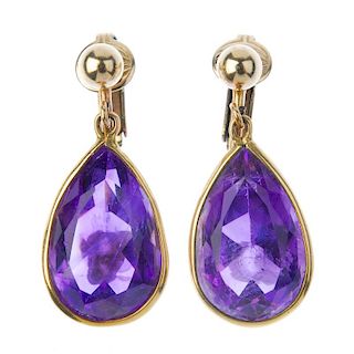 A pair of amethyst ear pendants. Each designed as a pear-shape amethyst collet, suspended from a bea