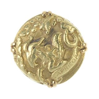 A dress ring. Of circular outline, depicting the Capricorn zodiac sign, to the bifurcated shoulders.