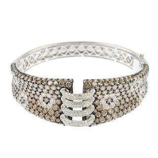 A diamond hinged bangle. Designed as a series of four brilliant-cut diamond half-hoops, to the simil