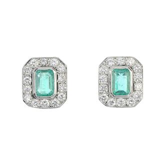 A pair of emerald and diamond cluster ear studs. Each designed as a rectangular-shape emerald, withi