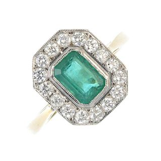 An emerald and diamond cluster ring. The rectangular-shape emerald, within a brilliant-cut diamond s