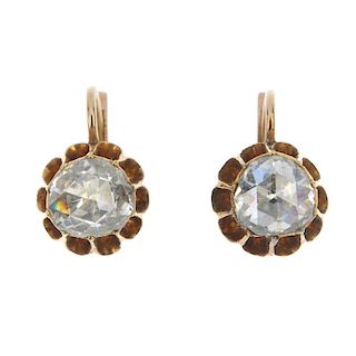 A pair of diamond ear pendants. Each designed as a rose-cut diamond, within an elongated claw settin