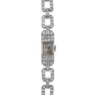 A mid 20th century platinum diamond cocktail watch. The rectangular-shape cream dial with Arabic num