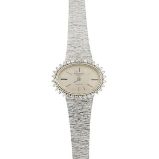 A lady's 1970s diamond cocktail watch. The oval-shape dial, with baton markers, within a single-cut