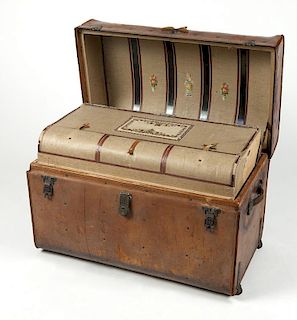A vintage leather barrel-top steamer trunk