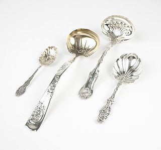A group of four sterling silver ladles and spoons