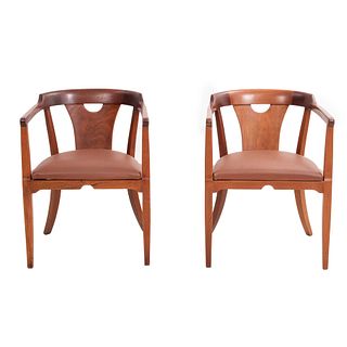 PAR DE SILLAS. SXX. Elaboradas en madera de caoba. Respaldos curvos semiabiertos, asientos acojinados de piel color marrón.
