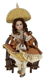 Reproduction Jumeau Automaton. 18" sitting bisque head doll with human hair wig, stationary glass eyes, on sitting body with key wind mechanism that p