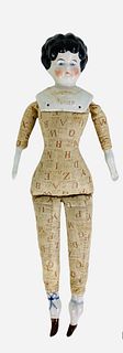 Low Brow china shoulder head doll "Marion". 16" doll with molded and painted hair and facial features, "Marion" and trim in gold, on printed alphabet 