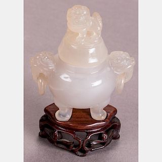 A Chinese Carved Agate Tripod Koro and Cover on a Carved Hardwood Stand.