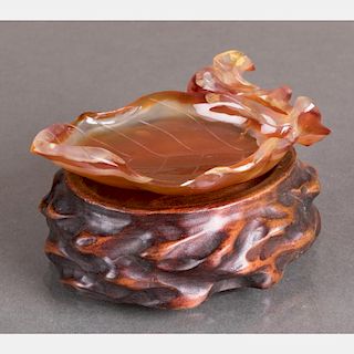 A Chinese Carved Agate Leaf Form Washer on a Carved Hardwood Stand.