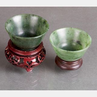 Two Chinese Carved Spinach Jade Cups on Carved Hardwood Stands.
