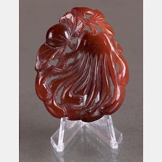 A Chinese Carved Red Jadeite Disk on a Carved Hardwood Stand.