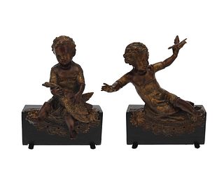 A pair of patinated metal putti figures
