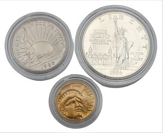 Three Piece 1986 Uncirculated Statue of Liberty Set, to include five dollar gold, one copper nickel half-dollar, along with one silver dollar.