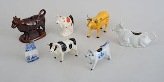 GROUP OF FOUR POTTERY COW CREAMERS, A YELLOW CAB" COW, A BLACK-SPOTTED COW AND A COW-FORM TOOTH PICK HOLDER"