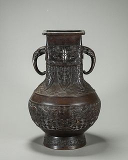 A taotie patterned copper vase with elephant head shaped ears 