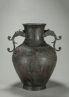 A dragon patterned copper vase with elephant head shaped ears 