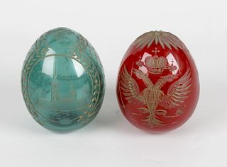 Two coloured glass eggs, each having intaglio decoration, in the manner of Faberge, one decorated wi
