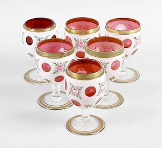 A matched set of six cranberry and white overlay drinking glasses, each with bucket bowl on prism cu