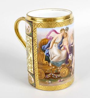 A late 19th century Vienna porcelain mug, with gilded and hand painted panel decoration depicting th