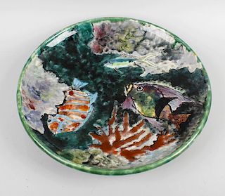 A French majolica charger, the light and dark green merging glaze ground decorated with tropical fis