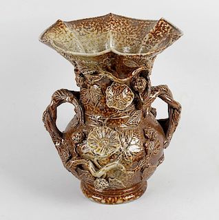 A saltglazed stoneware twin handled vase, of bulbous form below a tall flared and lobed neck, the tw