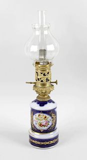 A porcelain oil lamp, having fluted glass shade above a grapevine pierced mount and tall porcelain b