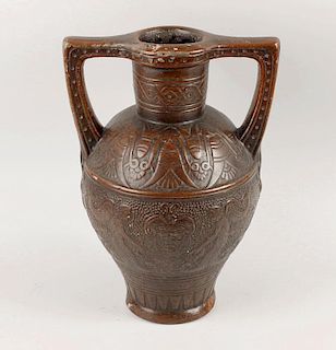 A twin handled stoneware vase, of archaic-style decorated in low relief with masks and mythical figu