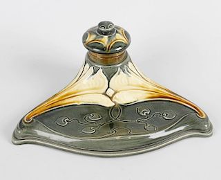 A German Art Nouveau porcelain inkstand, with pen tray before the raised and covered inkwell, the wh