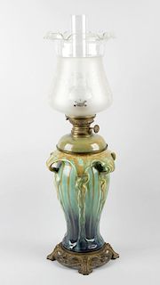 An Art Nouveau oil lamp, having removable glass reservoir with brass fittings above the tapering bod
