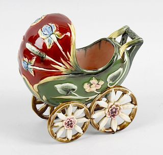 A majolica pram, decorated with stylised flowers upon a green and red glaze ground, raised upon four