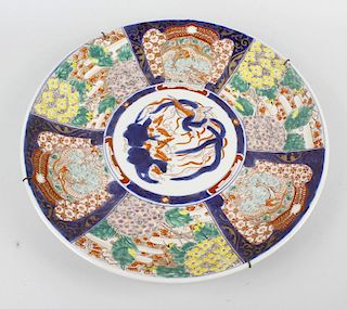 An early 20th century Japanese porcelain charger, decorated with central circular panel depicting a