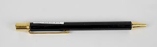 A Must de Cartier ballpoint pen, with black resin body and gold coloured clip marked with Cartier em
