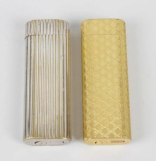 Two Cartier lighters. The first gold plated, with all-over trellis effect engine turning, the second