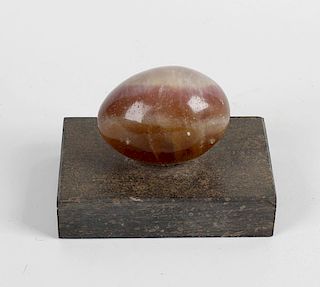 A fluorspar paperweight, modelled as an egg of translucent, purple and brown colouring upon rectangu