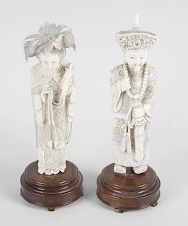 A pair of carved ivory figures, modelled as a Mandarin Emperor and Empress, each wearing detailed el