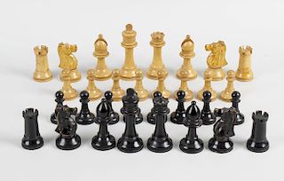 An oak cased Staunton pattern chess set, comprising ebonised and natural pieces each of turned form,