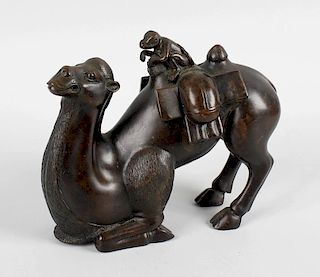 A bronze figure, modelled as a camel in half seated position having loaded saddle and monkey rider,