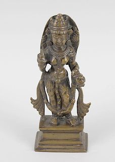 An Indian bronze modelled as a female deity, right hand raised in mudra, raised on rectangular base,
