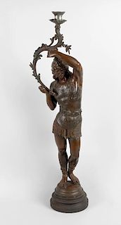 A large spelter candlestick, modelled as an ancient Grecian soldier stood raising the acanthus curve