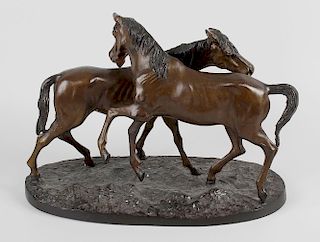 A reproduction bronze ‘accolade’ group, modelled as two horses, stood upon a naturalistic oval base