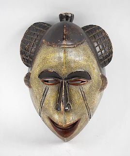 An African tribal carved softwood maskPossibly Punu, GabonModelled with top-knot and unusual hatch-c