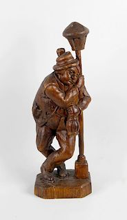 A large carved wooden figure, modelled as a drunk male stood supporting himself upon a lamppost, rai