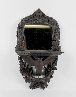 A late Victorian carved oak mirror bracketThe arched plate within carved border of roses, lily-of-th