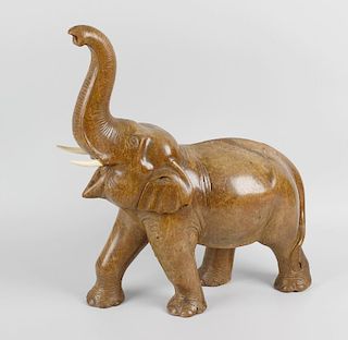 A large carved hardwood study of an Elephant, his head tilted back and trunk held aloft, with carved