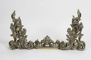 A 19th century French gilt brass chenet. The pierced rail flanked by large twin scrolling foliate fi