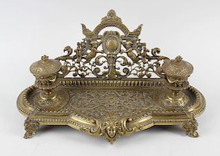 A French gilt desk stand, having mask and foliate cast tray with dual urn inkwells before the acanth