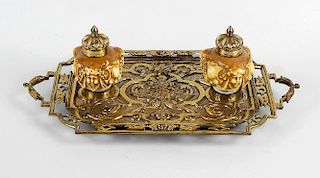 A brass and porcelain desk stand, having mask and acanthus cast rectangular tray within a pierced bo